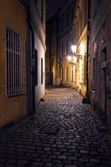 view of a dark and illuminated cobblestone street in the old town of prague at night 2021