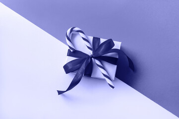 Christmas Gift Box with Candy colored in trendy color of year 2022 Very Peri. Creative Minimal Composition