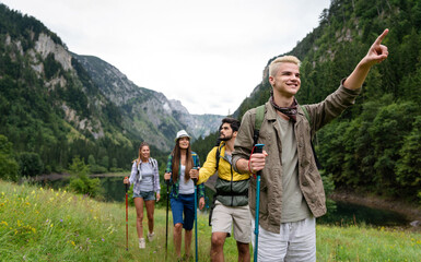 Group of friends with backpacks doing trekking excursion on mountain