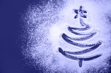 Christmas Tree Drawn on the Scattered Flour colored in trendy color of year 2022 Very Peri. Minimal Holiday Concept