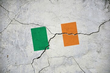 An old image of the flag of Ireland on a wall with a crack.