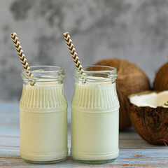 Coconut milk and coconuts on a light background