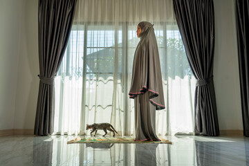 Muslim woman praying in Living room at Home. Religion Duty Diary