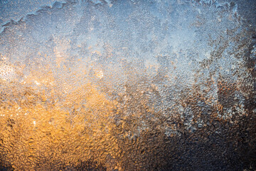 Magical winter patterns on the glass.The texture of the glass covered with frost in winter in cold. Natural phenomena. Frozen water on the window.