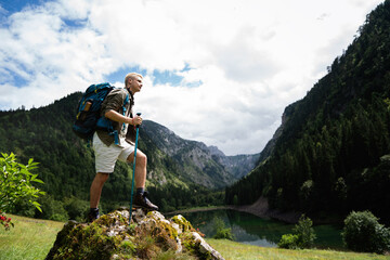 Obraz premium Active hiker hiking, enjoying the view, looking at mountain landscape