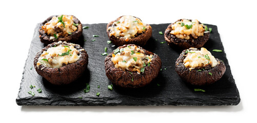 Baked mushroom caps stuffed with chicken meat, parmesan cheese, garlic and herbs. isolated on white background.