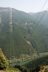 山奥に設置され川を渡る高圧線の鉄塔