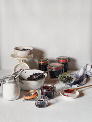 Bowl of fresh blackberries, sugar, glass jars with blackberry jam