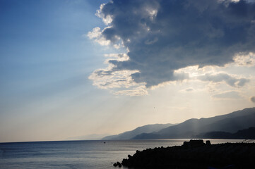 晴れた日の雲の切れ目から海に射す光芒