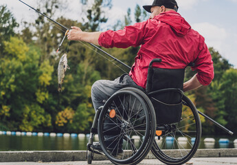 Person with a physical disability in a wheelchair fishing from fishing pier.