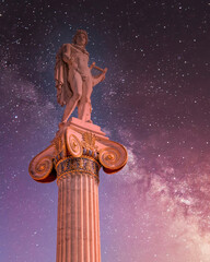 Apollo the ancient Greek god of poetry and music under starry night sky, Athens Greece