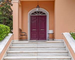 elegant house front marble stairs and arched entrance bordeaux-colored door
