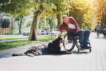 Happy young man with a physical disability in a wheelchair with his dog.