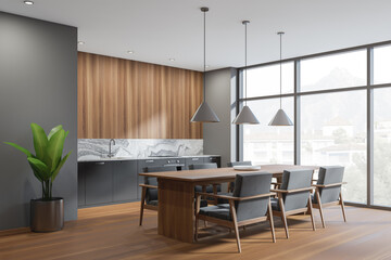 Dark kitchen interior with table and seats, wooden floor and window