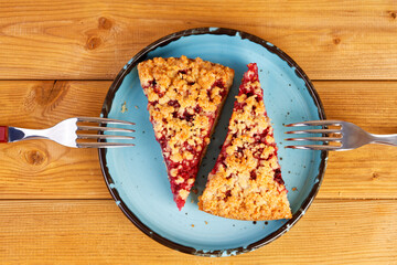 Closeup two piece of homemade raspberries pie with streisel on wooden table. Top view.