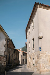 A street in the empty city of Oia, Galicia, Spain during the siesta. Signs of the way of Santiago on the wall.