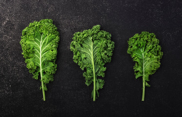 Kale cabbage. Green vegetable leaves, top view on black background, healthy eating, vegetarian food