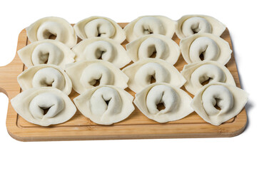 The process of making home-made dumplings. Raw homemade dumplings on a wooden board. Molding dumplings.