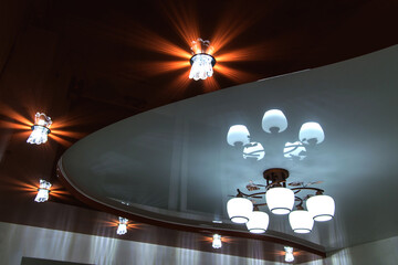 stretch ceiling with chandelier and lamps