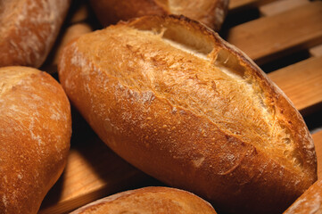Appetizing fresh hot artisan bread. Close-up of a loaf of delicious bread on a wooden pallet