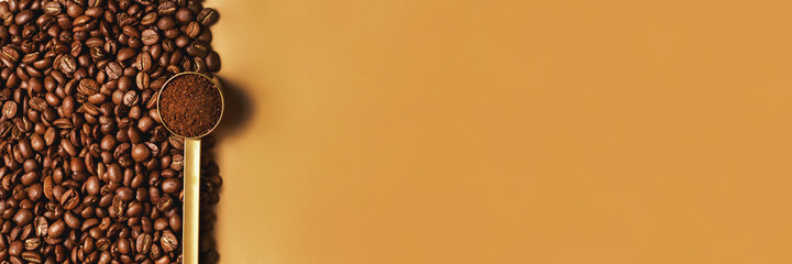 A golden spoonful of ground coffee on it of roasted coffee beans with room for text. Banner for advertising coffee and cafes