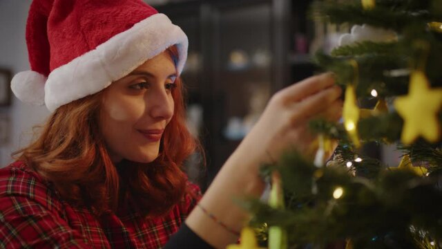 Giovane ragazza sistema l'albero di Natale