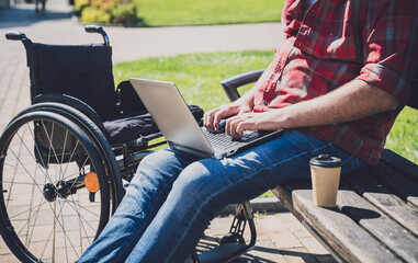 Freelancer with a physical disability in a wheelchair working at the park