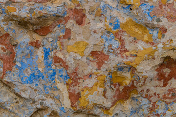 Abstract of multi-colored layers of peeling paint on stonework and walls of old buildings.