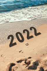 2022 wtitten on tropical beach with bokeh sun light wave abstract background.
