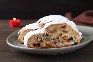Traditional Christmas Stollen with icing sugar on wooden table