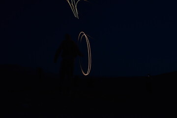 Iron wool circle drawing light fireworks. Burning Steel Wool spinning, Trajectories of burning sparks at night. Movement light effect, steel wool fire hoop. long exposure light painting, Pyrotechnic