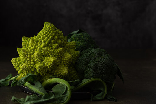 Romanesco cabbage and broccoli close up on dark background