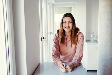 Young woman sitting relaxing in a high key apartment