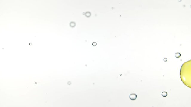 Capsule pills, Omega 3 gold oil capsules. Macro shot of Pills falling down in water and air bubbles on white background. The medicine concept, health care, treatment. Slow motion. High quality FullHD