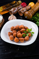 Traditional fried pelmeni, ravioli, dumplings filled with meat on black background, copy space.
