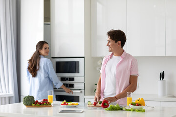 Happy couple cooking healthy food in kitchen lifestyle meal preparation