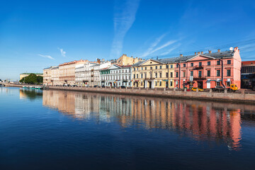 Saint-Petersburg. Tenement houses on the Fontanka river embankment and their reflection in the water in the early morning. Russia