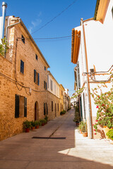 Fototapeta na wymiar Typically paved and narrow mediterranean streets at the old town of Alcudia, Mallorca island, Spain(vertical)