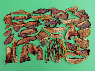 Rectangle of dried porcini mushrooms on green background, not covering margins.