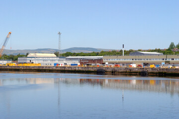 River View of Industrial Buildings and Cranes against Blue Sky