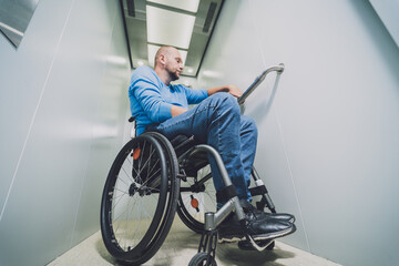 Person with a physical disability who uses wheelchair using lift in building