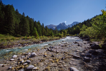 Sommerstimmung mit Morgenlicht am Gebirgsfluss Rißbach im Karwendel Gebirge in Tirol, Österreich mit Bergen als Hintergrund 