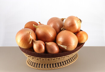onions (Latin Allium cepa) lie in a wicker plastic container