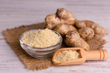 Fresh dried ginger powder on a white wooden background.