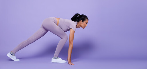 Full length Asian slim Fitness woman exercise warm up stretch spring jumps legs, peri purple