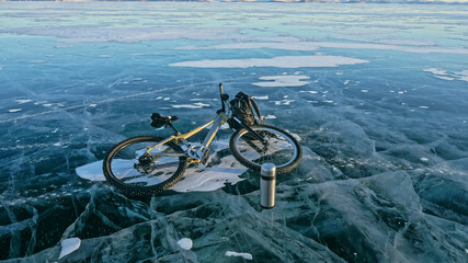 Fototapeta premium Man and his bicycle on ice. He looks at the beautiful ice in the