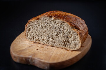  Fresh baked Sliced Fermented  Sourdough Buckwheat Bread on wooden cutting board isolated on blackboard Side View