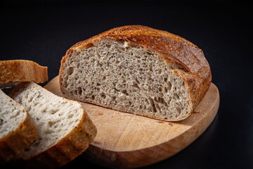  Fresh baked Sliced Fermented  Sourdough Buckwheat Bread on wooden cutting board isolated on blackboard Side View With Slices