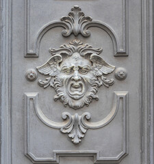 screaming human face with wings, mythological figure carved on palace door