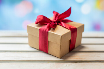 surprise gift box with a red bow for the holiday birthday and valentine's day on a shiny bokeh...